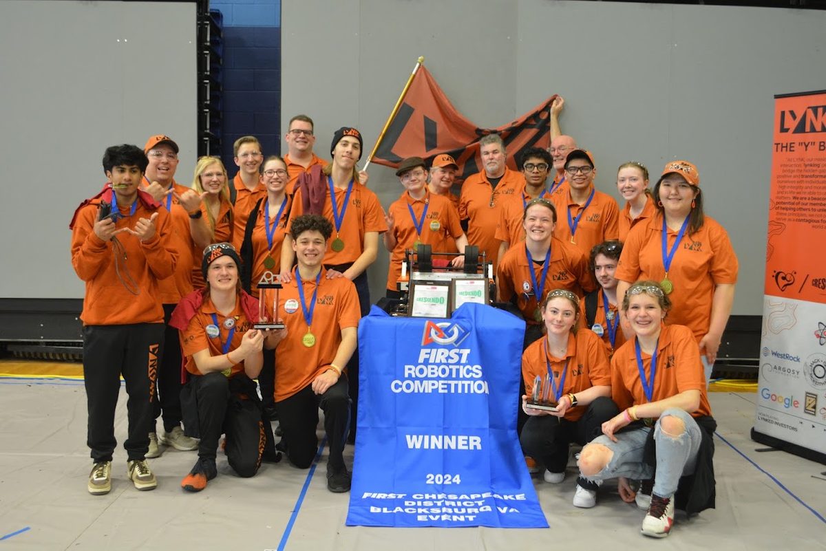The LYNK 9496 team celebrating with a FIRST Robotics Competition winner banner